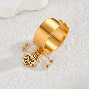 Close-up of 18k gold stainless steel open ring with crystal bead and spiral charm