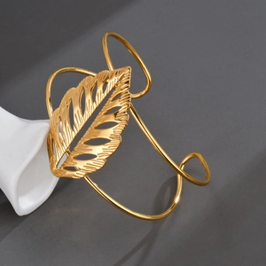 Detailed close-up of a hollow golden leaf open cuff bracelet with intricate textures