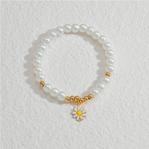 Detailansicht des Perlenarmbands mit weißen Perlen, Goldakzenten und Gänseblümchen-Anhänger