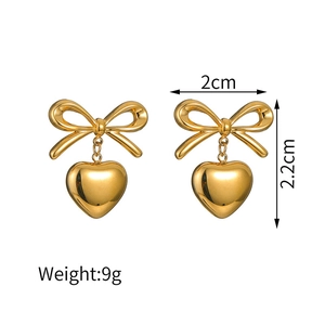 Detailed view of gold bow and heart earrings with dimensions 2cm by 2.2cm and 9g weight