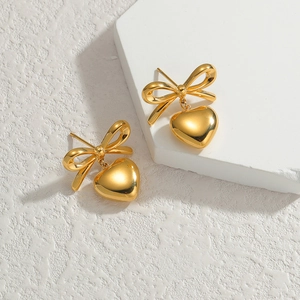 French bow heart earrings in gold-plated stainless steel on a white stone base