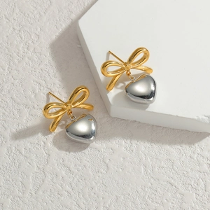 18K gold-plated bowknot and silver heart drop stud earrings on a geometric stand