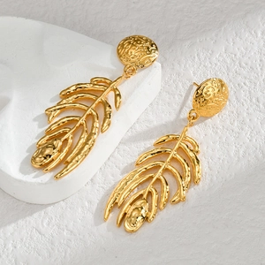 Détail macro de boucles d'oreilles en acier inoxydable doré à l'or 18 carats avec texture