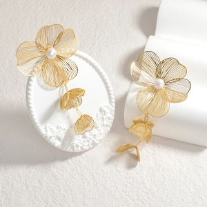 Golden cutout flower earrings with white pearls and long tassels in 18k gold finish