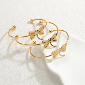 Detailed macro view of 18K gold plated dragonfly bangle set with inlaid zircon stones