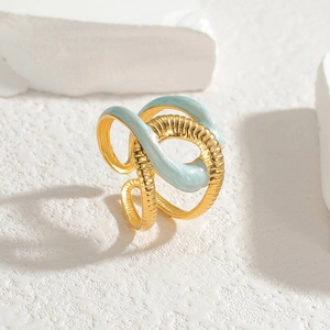Macro shot of abstract gold-plated ring with light blue enamel on stone background