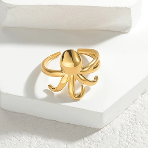 Polierter goldener Oktopus-Ring aus Titanstahl auf einem dekorativen Steinsockel