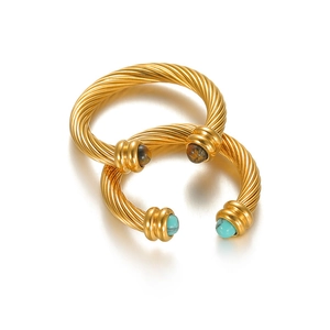Detail of gold cable twist rings featuring turquoise and tiger eye stone settings