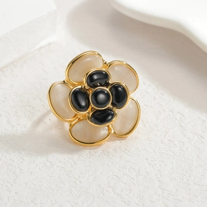 Detailed close-up of camellia flower ring with opal petals and black gem center
