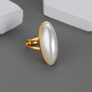 Bague dorée avec nacre blanche ovale sertie sur un anneau au style minimaliste moderne