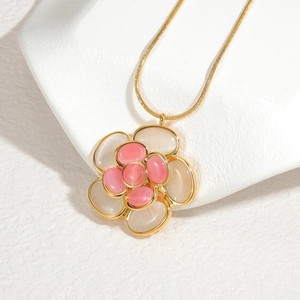 Elegante collana con ciondolo a camelia dorata con petali di pietre preziose rosa e crema
