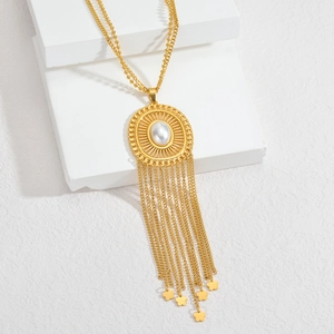Sautoir ethnique fait main avec pompon doré et perle blanche sur pendentif filigrane