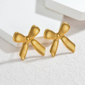 Boucles d'oreilles nœud en acier inoxydable poli avec texture striée sur socle blanc
