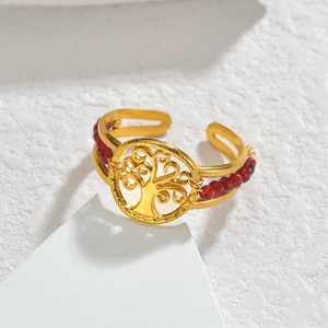 Détail d'un bracelet doré arbre de vie réglable avec perles rouges sur fond marbre