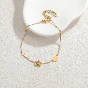 Bracelet élégant en acier doré avec breloques croix, cœur et couronne en zircone