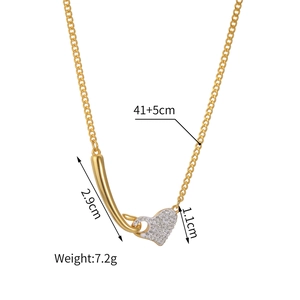 Elegant gold heart pendant necklace with rhinestones and curved bar on white background