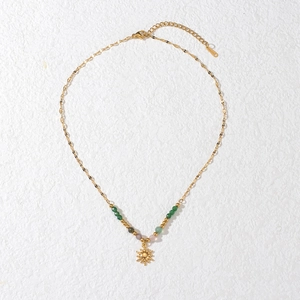 Bohemian gold sun pendant necklace with colorful beads on a clean white textured background