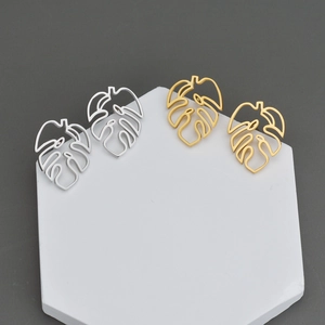Boucles d'oreilles feuilles de monstera en acier inoxydable doré et argenté sur pierre