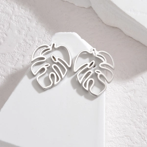 Boucles d'oreilles feuilles de monstera en acier inoxydable argenté sur pierre