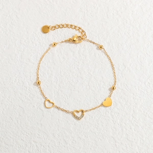 Elegant gold stainless steel bracelet with hollow heart charms and sparkling zirconia