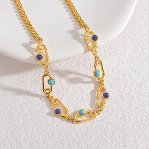 Détail du collier en chaîne dorée avec pierres précieuses bleu marine et turquoise
