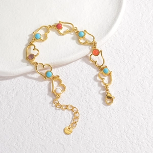 Détail du bracelet cœur en acier doré avec des incrustations de pierres multicolores