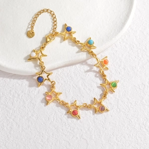 Détail macro du bracelet étoile en acier inoxydable doré avec perles colorées et breloque