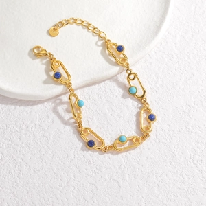 Vue détaillée du bracelet en acier inoxydable doré avec perles d'émail bleues et fermoir mousqueton