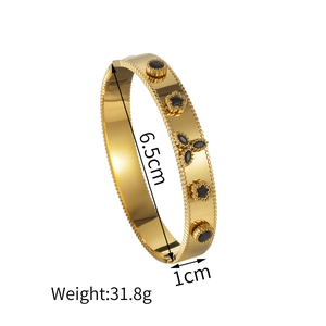 Bracciale rigido dorato in acciaio inossidabile con motivi neri a rilievo e bordo perlato