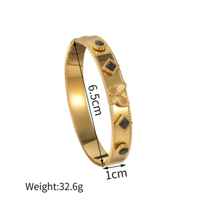 Bracciale a farfalla dorato con pietre nere e bordi perlati in acciaio placcato oro 18K