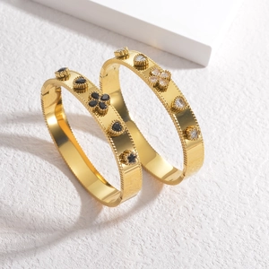French vintage gold bracelets with clover and heart patterns on marble background