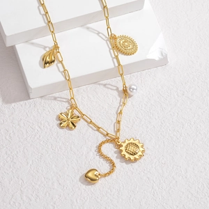 Detailed view of gold bohemian necklace with heart, pearl, and floral charms on stone