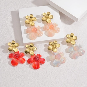 Detail of floral earrings with translucent resin petals and gold metallic studs