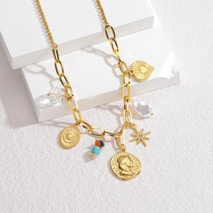 Vintage bohemian gold necklace with heart, pearl, and crystal charms on geometric stand