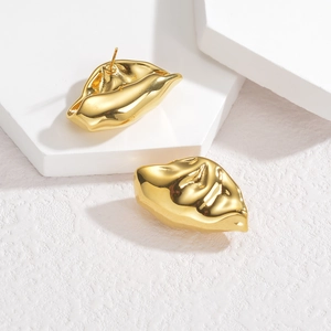 Retro hammered gold lip shaped stud earrings in polished stainless steel on white block