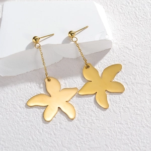 Elegant gold flower drop earrings with brushed metal texture on white stone blocks