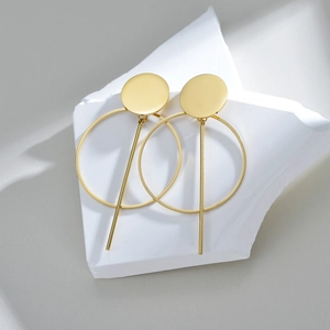 Boucles d'oreilles géométriques dorées avec barres verticales sur pierres marbre