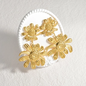 Vintage 18K gold plated sunflower drop earrings on a white decorative tray