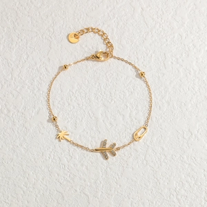 Golden stainless steel bracelet featuring palm tree, airplane, and flip-flop pendants