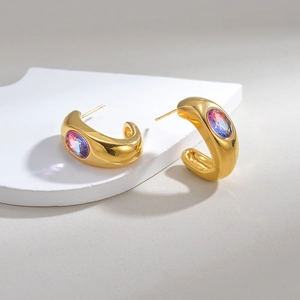Polished gold C-shape titanium earrings featuring a vibrant purple zircon inlay