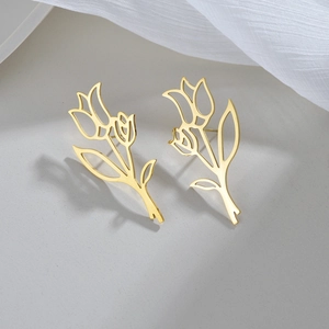 Eleganti orecchini a goccia a forma di tulipano traforato dorato su sfondo morbido