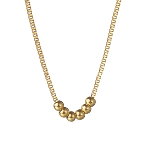 Collier chaîne box dorée avec six perles polies de style minimaliste sur fond blanc