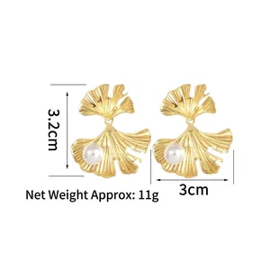 Ginkgo leaf earrings in gold-tone stainless steel with white pearls on a white background