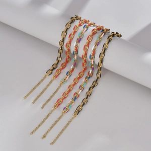 Lot de cinq bracelets chaînes en acier doré avec maillons en émail coloré sur un socle