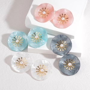 Détail de boucles d'oreilles pétales en acrylique marbré rose, bleu, gris et blanc