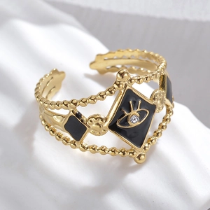 Macro view of gold stainless steel evil eye ring with black enamel and white crystal detail