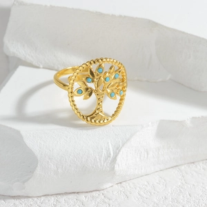 Golden Tree of Life ring with turquoise beads on minimalist stone background