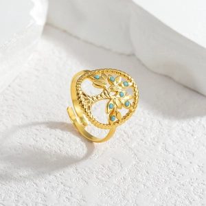 Gold stainless steel tree of life open ring with blue beads on white textured surface
