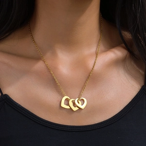 Pendentif trois cœurs creux entrelacés en acier inoxydable doré porté par mannequin