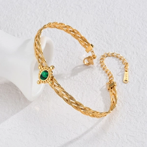 Golden woven stainless steel bracelet featuring an oval green turquoise heart stone
